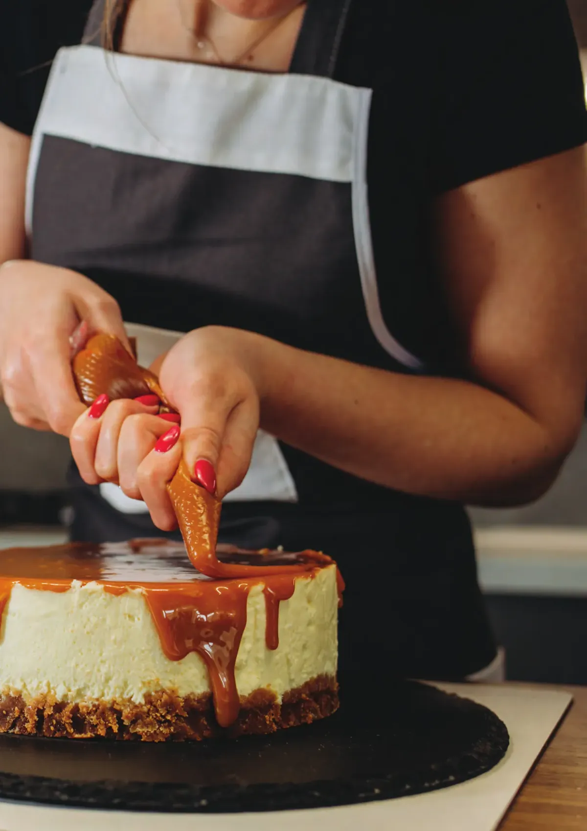 Uygulama laboratuvarında cheesecake üzerine karamel döken şef