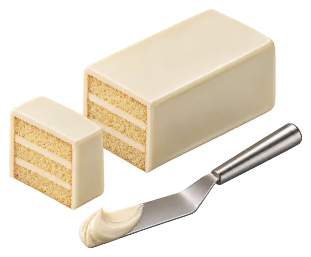Rectangular layered cake coated in white chocolate ganache, sliced, with a spatula of ganache